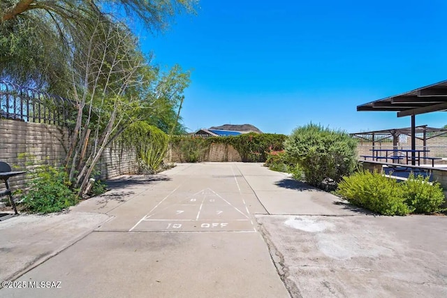 view of patio / terrace with shuffleboard and fence