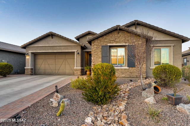 single story home with a tiled roof, stucco siding, a garage, stone siding, and driveway