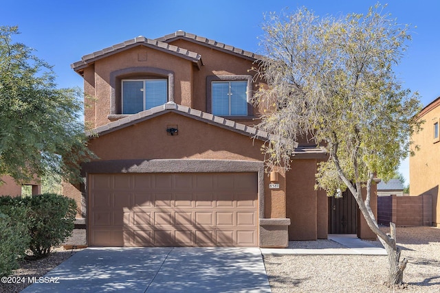 view of front of house featuring concrete driveway, fence, and stucco siding