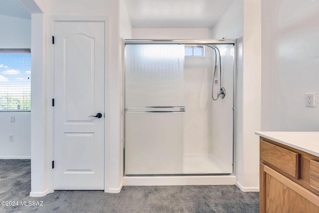 bathroom featuring vanity, carpet flooring, baseboards, and a stall shower