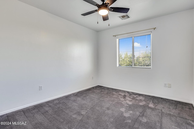 spare room with visible vents, baseboards, ceiling fan, and dark carpet