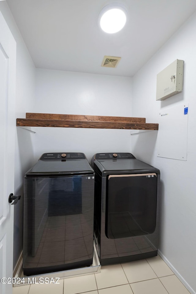 laundry room with visible vents, baseboards, light tile patterned floors, laundry area, and independent washer and dryer