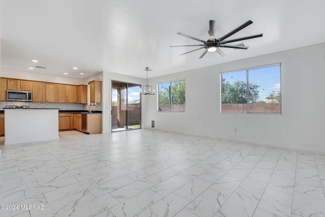 unfurnished living room with recessed lighting, marble finish floor, and baseboards