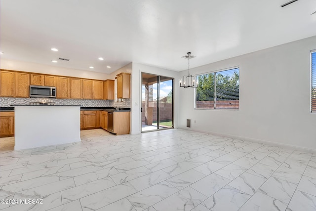 kitchen featuring dark countertops, marble finish floor, and appliances with stainless steel finishes