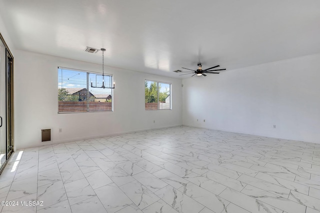 empty room featuring visible vents, marble finish floor, baseboards, and ceiling fan