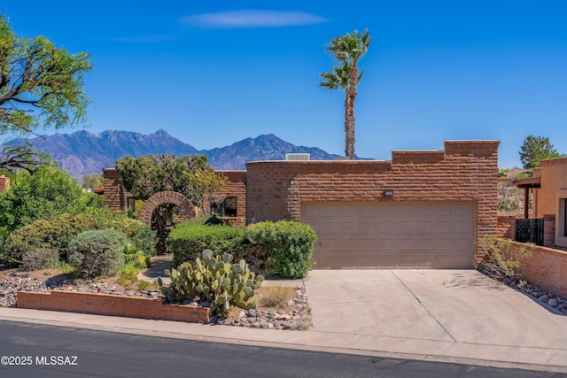 adobe home with driveway, a garage, and a mountain view