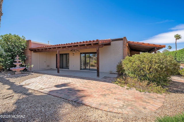 back of property featuring a patio area and a tiled roof