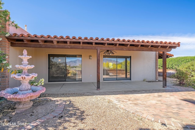 back of property featuring a tile roof and a patio area