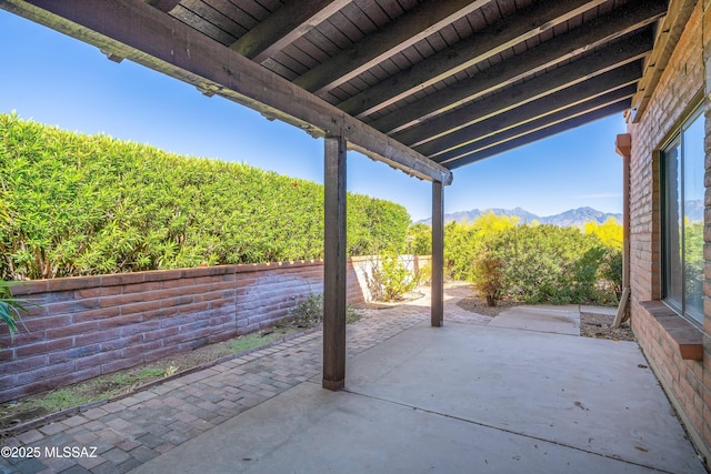 view of patio featuring a mountain view and fence