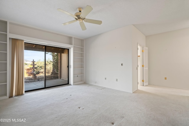 carpeted spare room with a ceiling fan and built in features