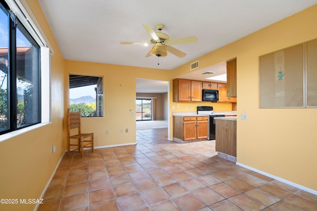 kitchen with light countertops, electric stove, visible vents, black microwave, and ceiling fan
