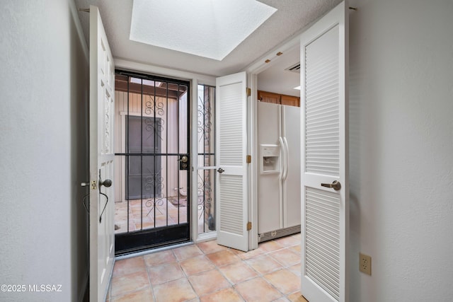entryway with light tile patterned floors, visible vents, and a skylight