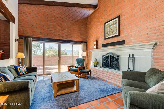 living room with a fireplace with raised hearth, tile patterned flooring, french doors, a towering ceiling, and beamed ceiling