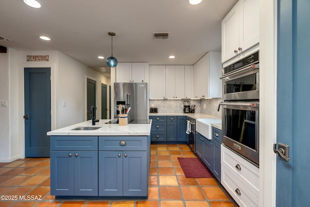 kitchen featuring tasteful backsplash, visible vents, stainless steel appliances, white cabinetry, and a sink