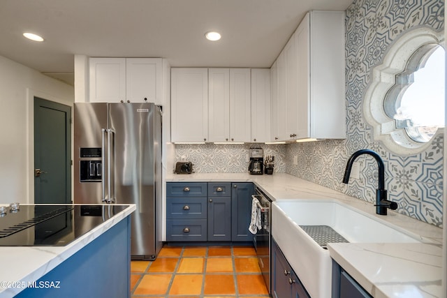 kitchen with tasteful backsplash, recessed lighting, appliances with stainless steel finishes, white cabinets, and a sink