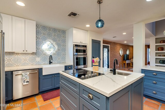kitchen with a sink, appliances with stainless steel finishes, and white cabinetry