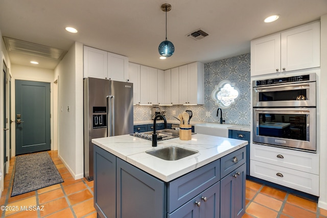 kitchen featuring pendant lighting, backsplash, appliances with stainless steel finishes, and white cabinetry