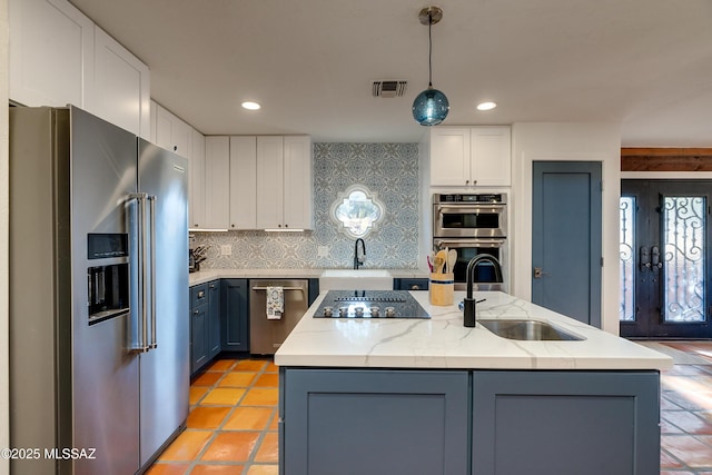 kitchen with a center island with sink, appliances with stainless steel finishes, white cabinetry, and a sink