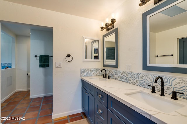 bathroom with tasteful backsplash, double vanity, and a sink