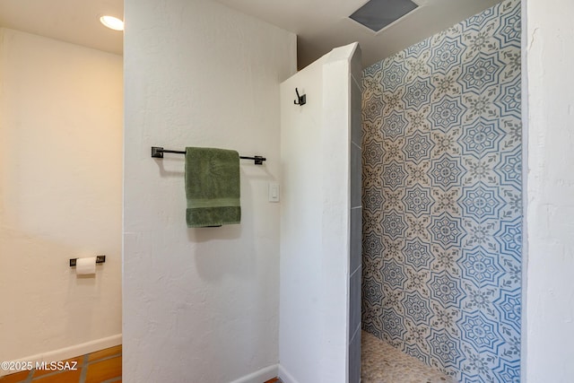 bathroom featuring baseboards and walk in shower