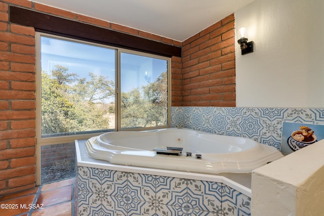 full bathroom featuring tile patterned floors, brick wall, a healthy amount of sunlight, and a whirlpool tub