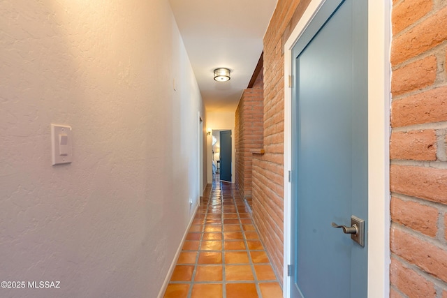 hallway with tile patterned flooring and baseboards