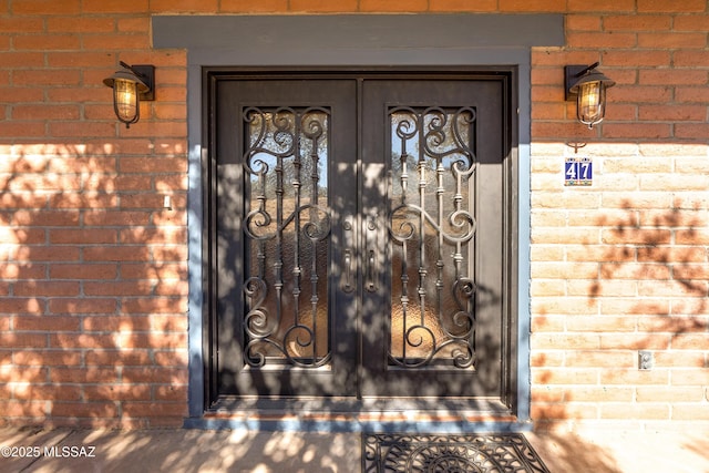 doorway to property with brick siding