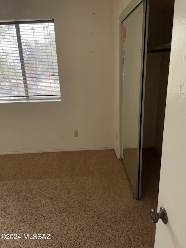 unfurnished bedroom with carpet flooring and a closet