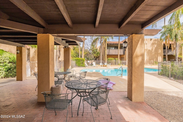 view of patio / terrace featuring a community pool and fence