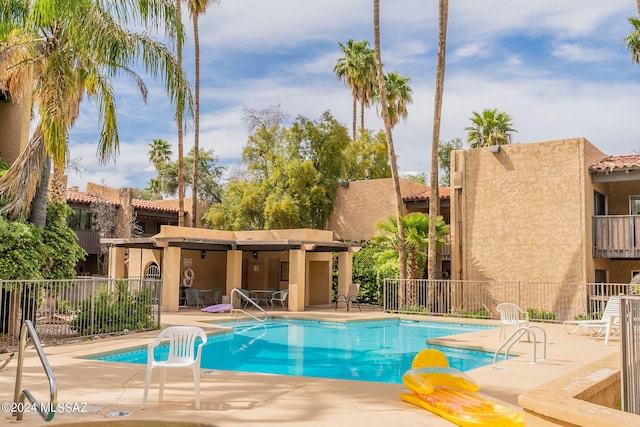 community pool featuring a patio area and fence