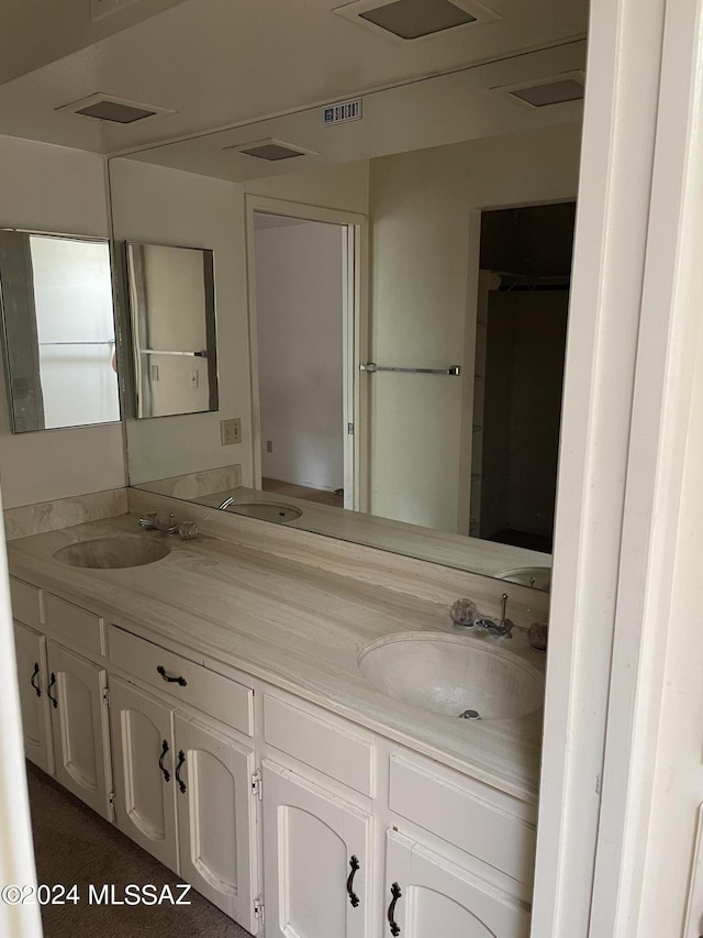 full bath featuring double vanity, visible vents, and a sink