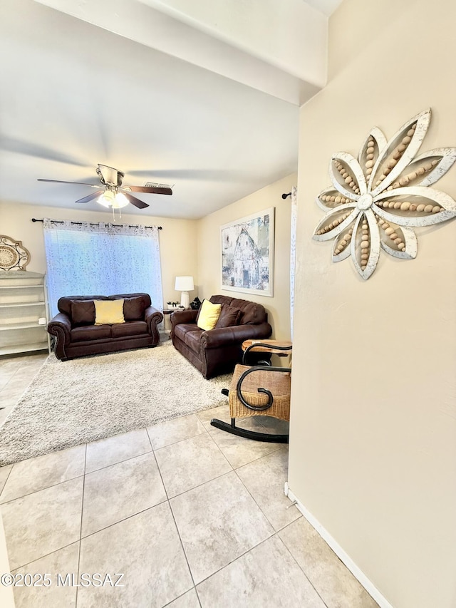 living area with a ceiling fan and tile patterned flooring