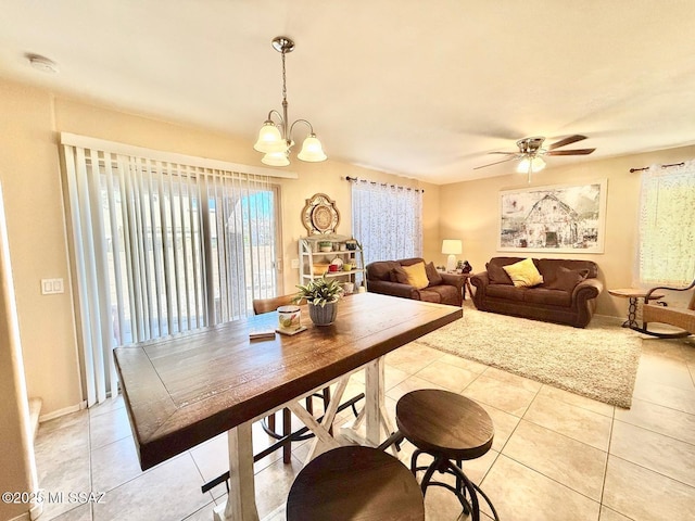 dining room with light tile patterned floors and ceiling fan with notable chandelier
