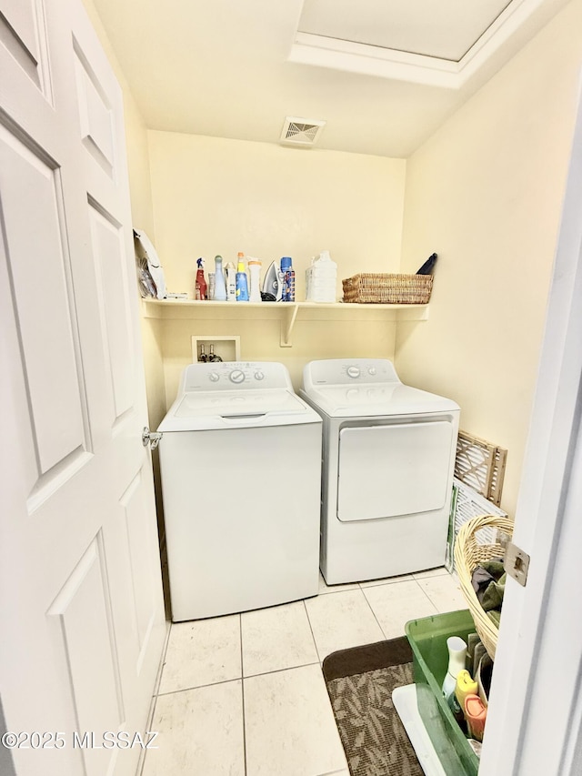 washroom with visible vents, washer and clothes dryer, laundry area, and light tile patterned floors