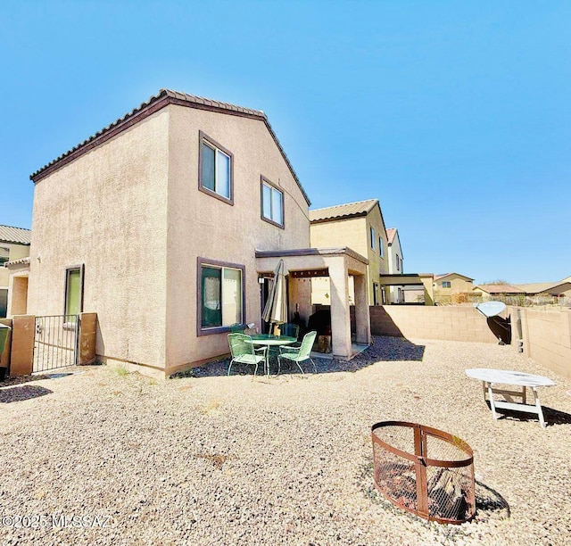 back of house with a patio, a tiled roof, a fenced backyard, and stucco siding