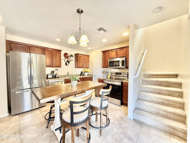 kitchen with visible vents, light countertops, light tile patterned floors, and stainless steel appliances