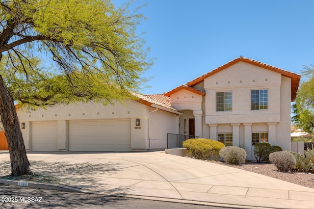 view of front of property featuring an attached garage, stucco siding, a tiled roof, and driveway