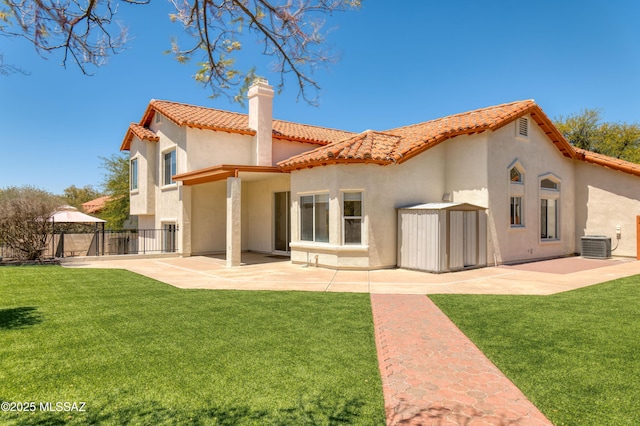 back of property with fence, a patio, stucco siding, a chimney, and a tiled roof