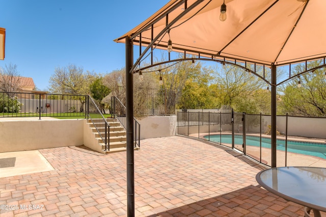 view of patio featuring stairway, a gazebo, fence, and a fenced in pool