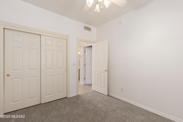 unfurnished bedroom with carpet flooring, ceiling fan, baseboards, visible vents, and a closet