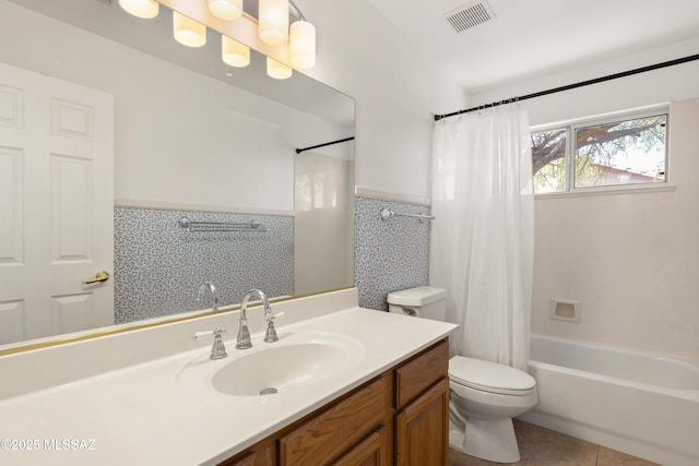bathroom featuring vanity, toilet, a wainscoted wall, shower / tub combo, and visible vents