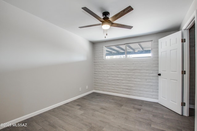 unfurnished room featuring ceiling fan, baseboards, and wood finished floors