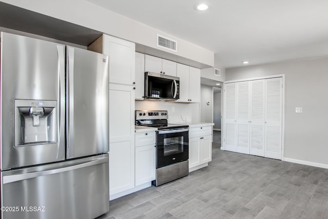 kitchen featuring white cabinetry, light countertops, visible vents, and stainless steel appliances