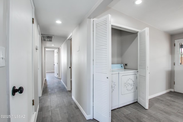 corridor with visible vents, baseboards, and wood finished floors