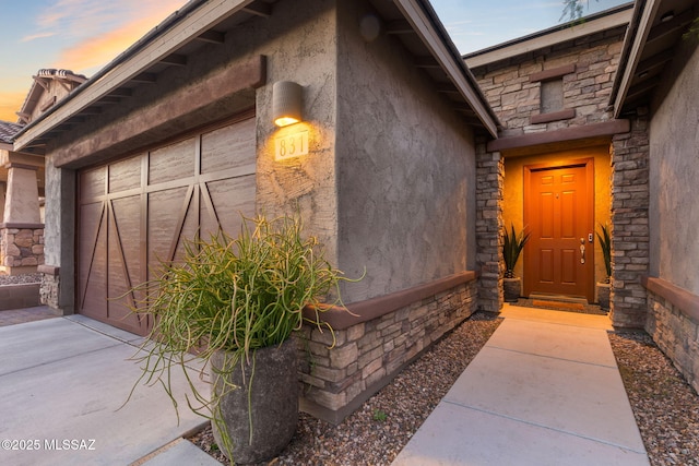 exterior entry at dusk with stone siding and stucco siding