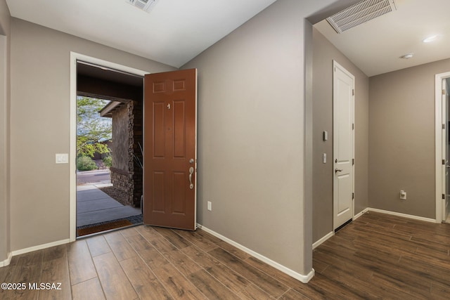 foyer entrance with visible vents, baseboards, and wood finished floors