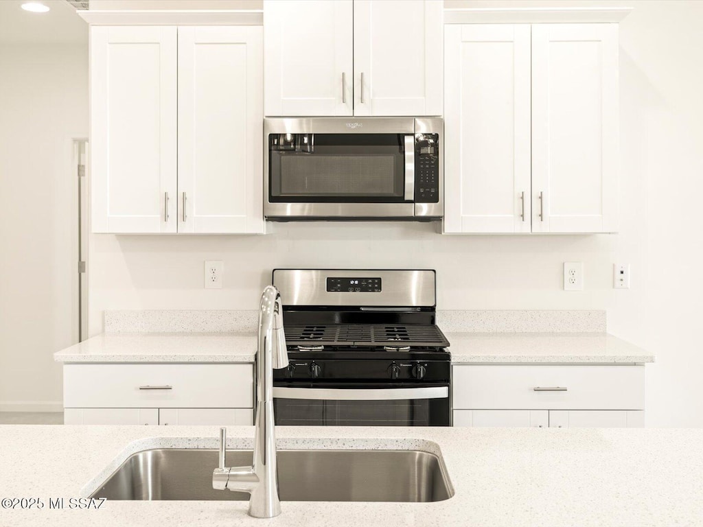 kitchen with white cabinets, a sink, and stainless steel appliances