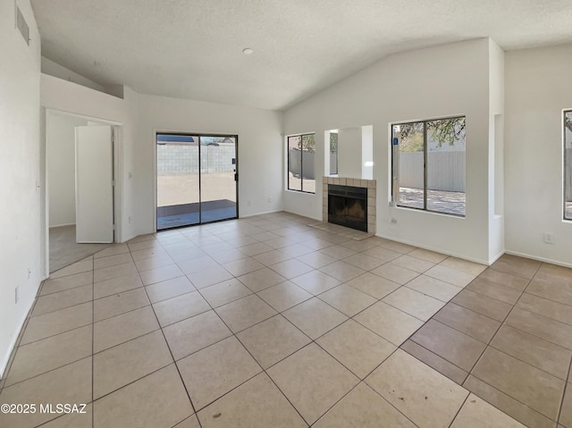 unfurnished living room featuring light tile patterned floors, visible vents, lofted ceiling, and a healthy amount of sunlight
