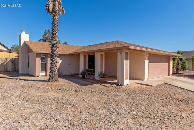 ranch-style home with stucco siding, driveway, a garage, and roof with shingles