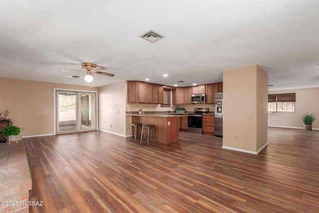 kitchen with stainless steel appliances, visible vents, open floor plan, and dark wood-style flooring